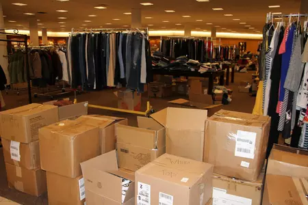 clothes hanging on racks and in boxes at the donation center